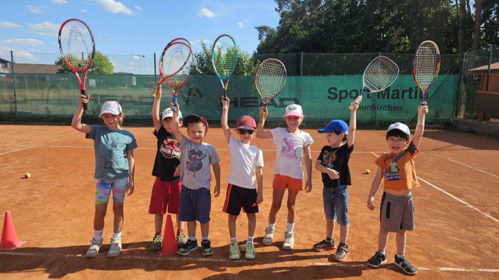 Jüngste Spieler:innen mit hoch gestreckten Tennisschlägern