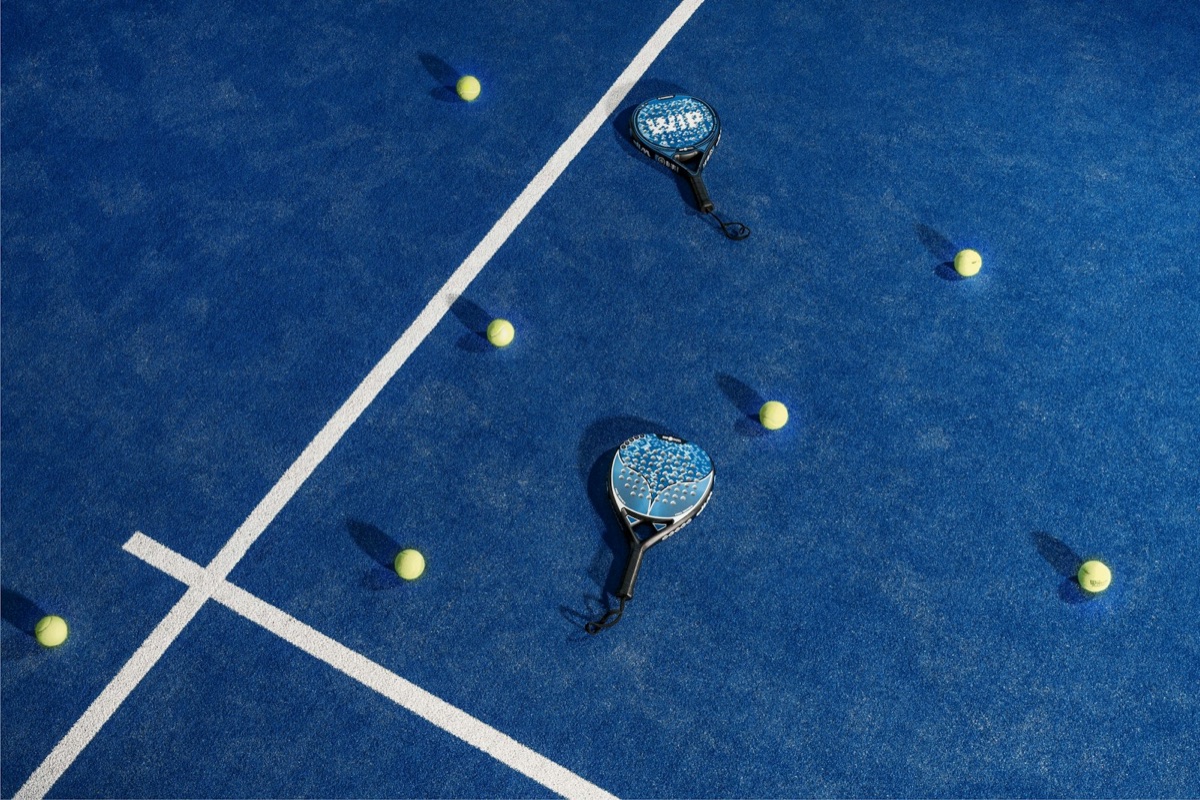 Padel-Schläger und Bälle auf blauem Padelplatz