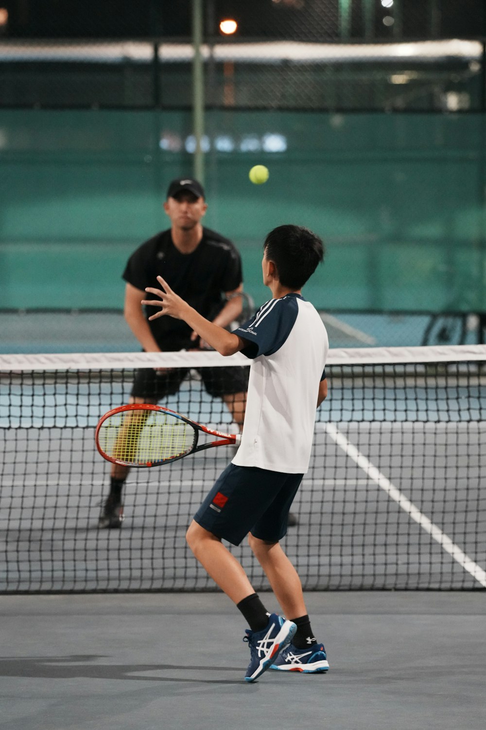 Trainer und Kind beim Tennistraining